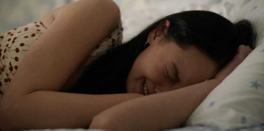 Belly (Lola Tung) sobs on her bed in The Summer I Turned Pretty | Agents of Fandom